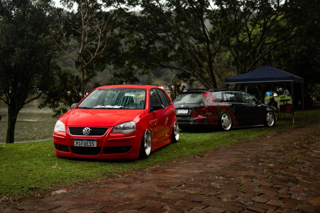Two modified cars parked near a lake