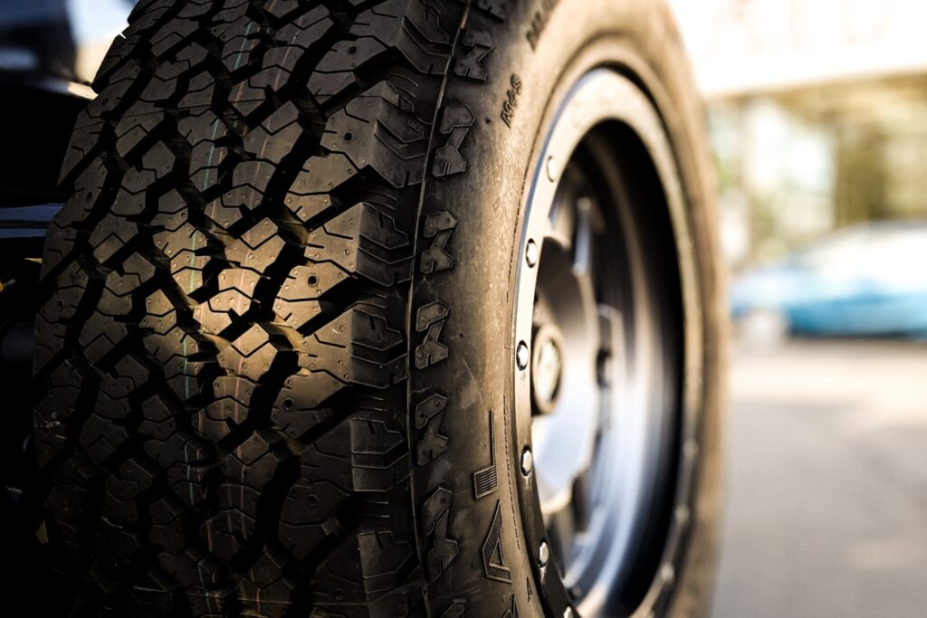 A brand new custom Jeep Tire and rim in a used wrangler in sunlight and shadow.