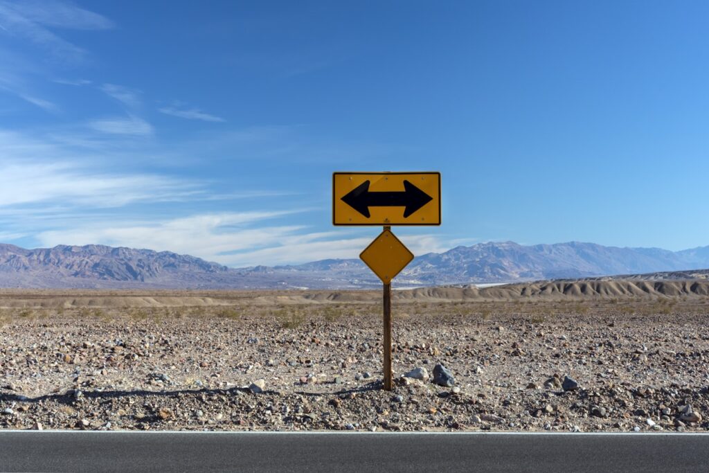 a road sign pointing in opposite directions in the desert